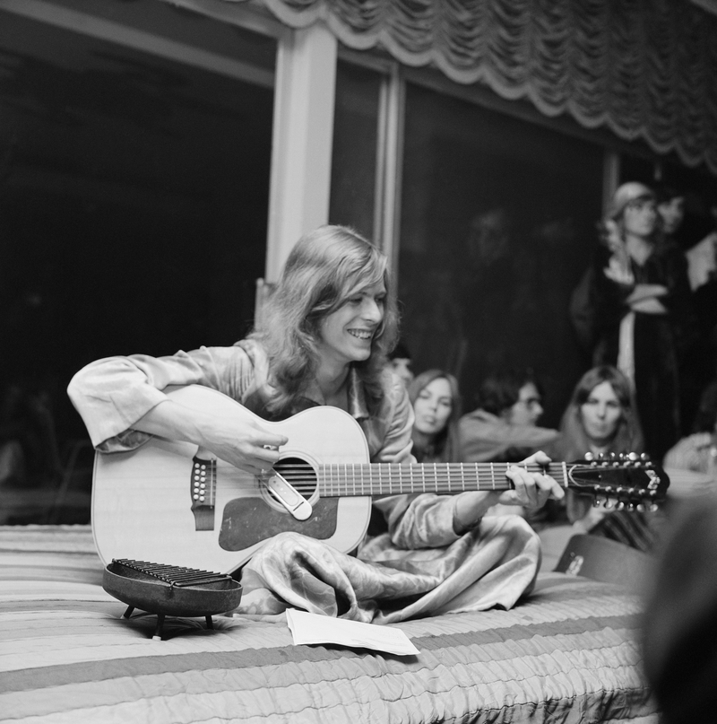 Un David Bowie muy joven y con apariencia de hippie da un espectáculo en una Fiesta. | Getty Images Photo by Earl Leaf/Michael Ochs Archives